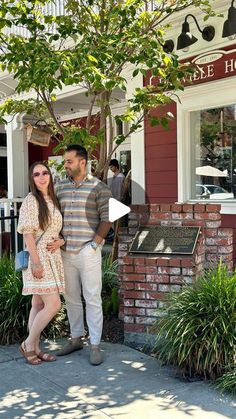 a man and woman standing in front of a building