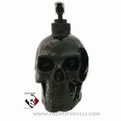 a black skull shaped bottle is shown against a white background