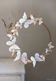 a wreath with white flowers and leaves hanging from the ceiling