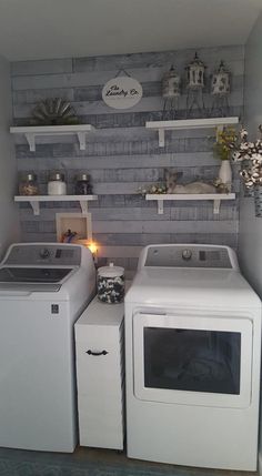 a washer and dryer sitting next to each other in a room with shelves on the wall