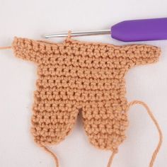 a crocheted piece of cloth next to a knitting needle