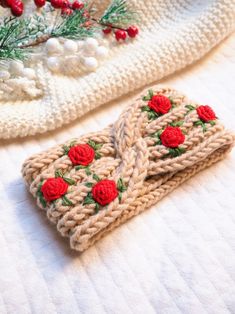 two crocheted cell phone cases sitting on top of a white blanket next to a christmas tree