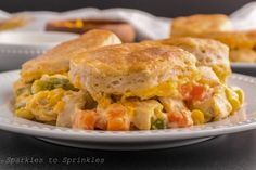 a close up of a plate of food with chicken and cheese biscuits on it