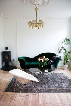 a living room filled with furniture and a rug on top of a hard wood floor