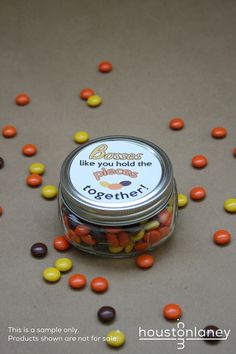 a jar filled with candy corn on top of a table next to a sign that says, you hold the pieces together thank you gift