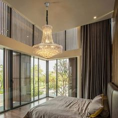 a bedroom with a chandelier hanging from the ceiling and sliding glass doors leading outside