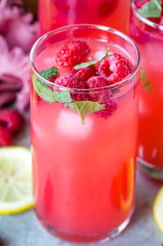 two glasses filled with raspberry lemonade and mint garnish