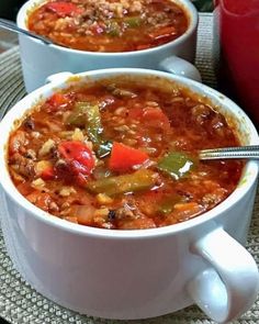 two white bowls filled with soup on top of a table