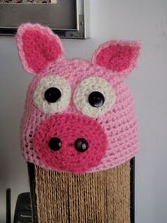 a crocheted pig hat is hanging on the wall