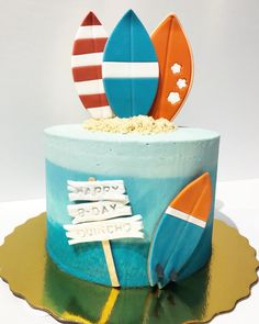 a birthday cake decorated with surfboards and sand