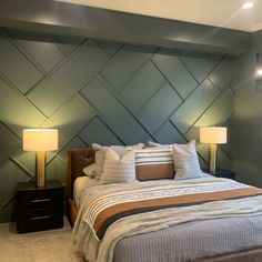 a large bed sitting next to two lamps on either side of the headboard in a bedroom