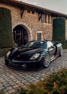 a black sports car parked in front of a house