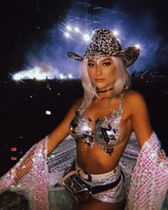 a woman wearing a leopard print hat and silver sequins in front of fireworks