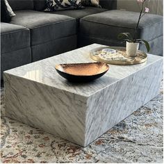 a marble coffee table with a bowl on it