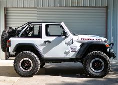 a white jeep is parked in front of a garage door with the word rubdon on it