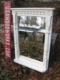 a mirror sitting on the ground next to a sign