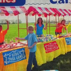 a group of people standing around a table with food on it in front of a tent