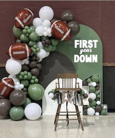 a balloon arch with footballs and balloons on it