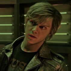 a young man in a leather jacket looking at the camera with an evil look on his face