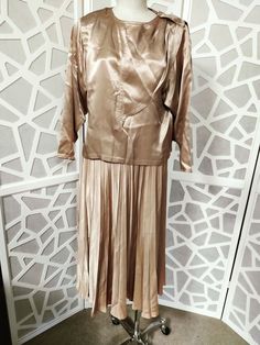 This is skirt and top set by the label Miss Selfridge in a small size and a definite old Hollywood look 1980s does 1940s in golden beige silky satin fabric. The top has a round neck and has a single button on one shoulder cover by a scarf design element which start at the front bodice and over the shoulder then loose down the back. The top is loose with dolman sleeves and soft shoulder pads. The skirt is pleated the below knee length and has a back nylon zipper. The condition is good just needs Pleated Skirt Set, Skirt And Top Set, Skirt And Top, Gold Satin, Satin Top, Scarf Design, Dolman Sleeve, Design Element, Skirt Top