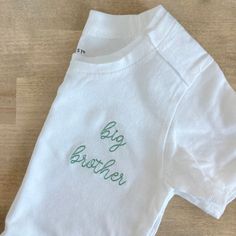 Simple and sweet! These cotton tees are made from 100% organic cotton. Please choose a thread color and font style at checkout. If no thread color is chosen, the default will be black. For sizes 12 months and smaller, the design will be stitched in the center of the t-shirt or bodysuit. In lieu of a white shirt you can have this design stitched on a fleece sweatshirt. If you are wanting a different design, more wording, or a different clothing style, please send me a message so we can discuss th Family Matching White T-shirt With Embroidered Text, White Family Matching T-shirt With Embroidered Text, White Embroidered T-shirt For Family Matching, Family Matching Cotton Tops With Custom Embroidery, Cute White T-shirt With Custom Embroidery, White Cute T-shirt With Custom Embroidery, White Basic T-shirt With Custom Embroidery, Cute White T-shirt With Letter Embroidery, White Cotton T-shirt With Custom Embroidery