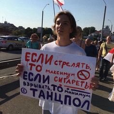 a man holding up a sign in front of a crowd