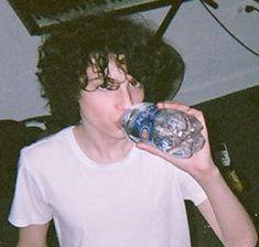 a young man drinking from a water bottle