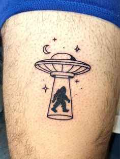 a man with a tattoo on his thigh that has an image of a bigfoot flying through the sky