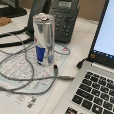 an open laptop computer sitting on top of a desk next to a can of soda