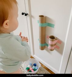 a baby is looking at some toilet paper rolls