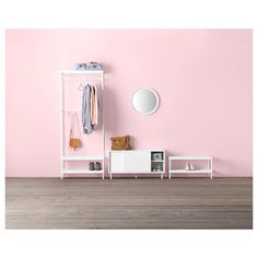 a white coat rack with clothes hanging on it in front of a pink wall and wooden floor