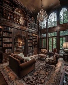 a living room filled with lots of books and furniture next to a large chandelier