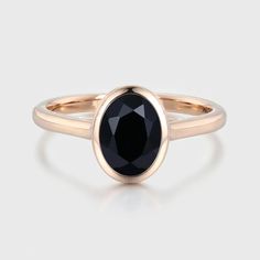 a rose gold ring with an oval black diamond