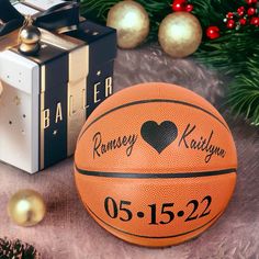 an orange basketball sitting on top of a table next to a christmas tree and presents