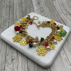 This golden snowflake charms chain bracelet is handcrafted personally for me, Derlis. You can Pick your size bracelet and favorite style: green/red/white or blue/golden/white beads. Also, you can pick your size bracelet. Each bracelet has about 9 assorted snowflake charms. Perfect Christmas gift for family, friends, love ones, co-workers, or yourself. MATERIALS:   - Antique golden Tibetan style Snowflake charms: Assorted sizes and styles - Pearl white glass round beads, 6mm - Rondelle faceted gl Holiday Handmade Gold Jewelry, Handmade Gold Jewelry For Holidays, Gold Christmas Festive Bracelets, Handmade Christmas Jewelry Bracelets, Handmade Christmas Bracelet Jewelry, Handmade Gold Charm Bracelet As Gift, Handmade Gold Charm Bracelet For Gift, Handmade Gold Charm Bracelet For Gift Making, Handmade Gold Holiday Jewelry