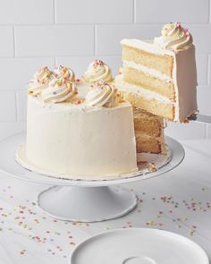 a white cake with one slice missing from it and the other half on a plate