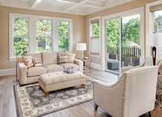 a living room with couches, chairs and windows in the middle of the room