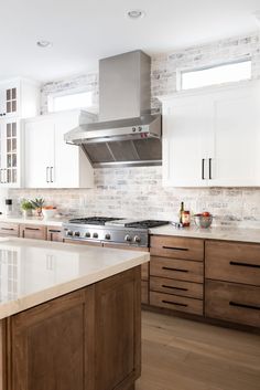 a kitchen with wooden cabinets and white counter tops, along with a stainless steel range hood