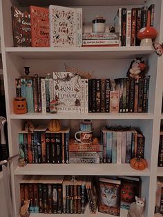 a white book shelf filled with lots of books