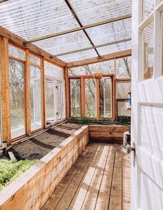 the inside of a greenhouse with lots of plants growing in it and windows on both sides