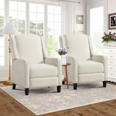 two white chairs sitting next to each other in a living room