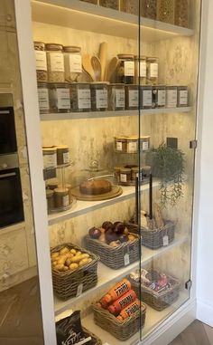 an open pantry filled with lots of food and containers on shelves next to a wall