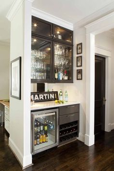 an image of a home bar with wine glasses on the top shelf and shelves above it