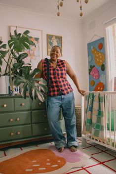 a woman standing next to a baby crib