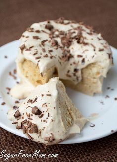 a piece of cake with white frosting and chocolate sprinkles on a plate