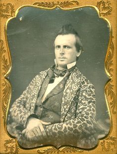 an old photo of a man in a leopard print coat and bow tie with his arms crossed