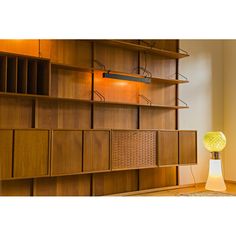 a room with wooden shelves and a lamp on the floor