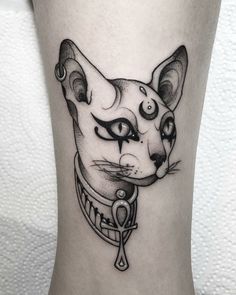 a black and white cat tattoo on the leg with an evil look to it's face