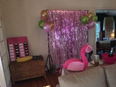 a living room decorated with pink and gold balloons, streamers and flamingo decorations