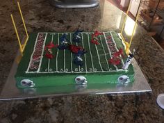 a football field cake on top of a granite counter next to a silver platter